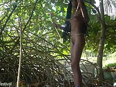 skinny tribe woman crafts bow for hunting outdoors
