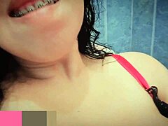 she's very horny and goes into the bathroom to masturbate, squirting for the first time