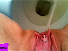 my shaved pierced pussy releasing a stream of pee in the bathroom