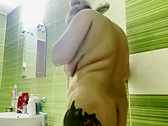 She lathers her huge shaved tits and smooth pussy in steamy shower